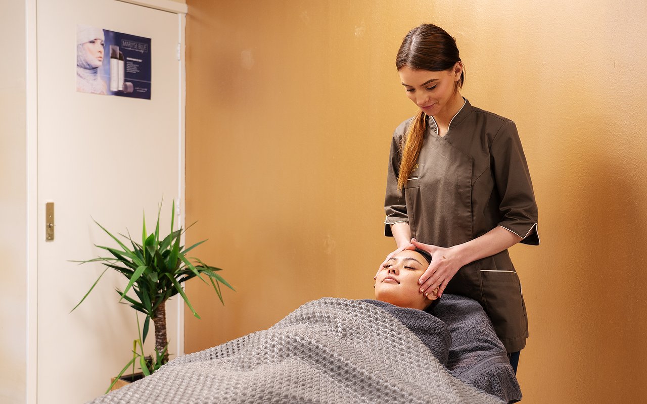 Ontspannende gezichtsmassage in de behandelkamer